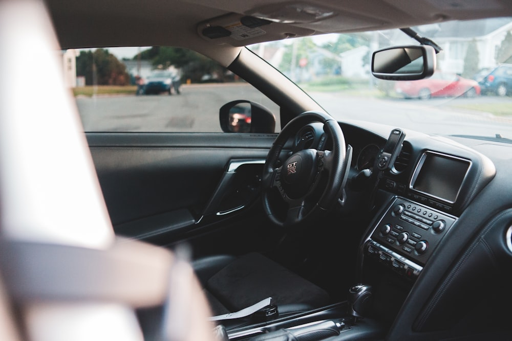 black car steering wheel during daytime