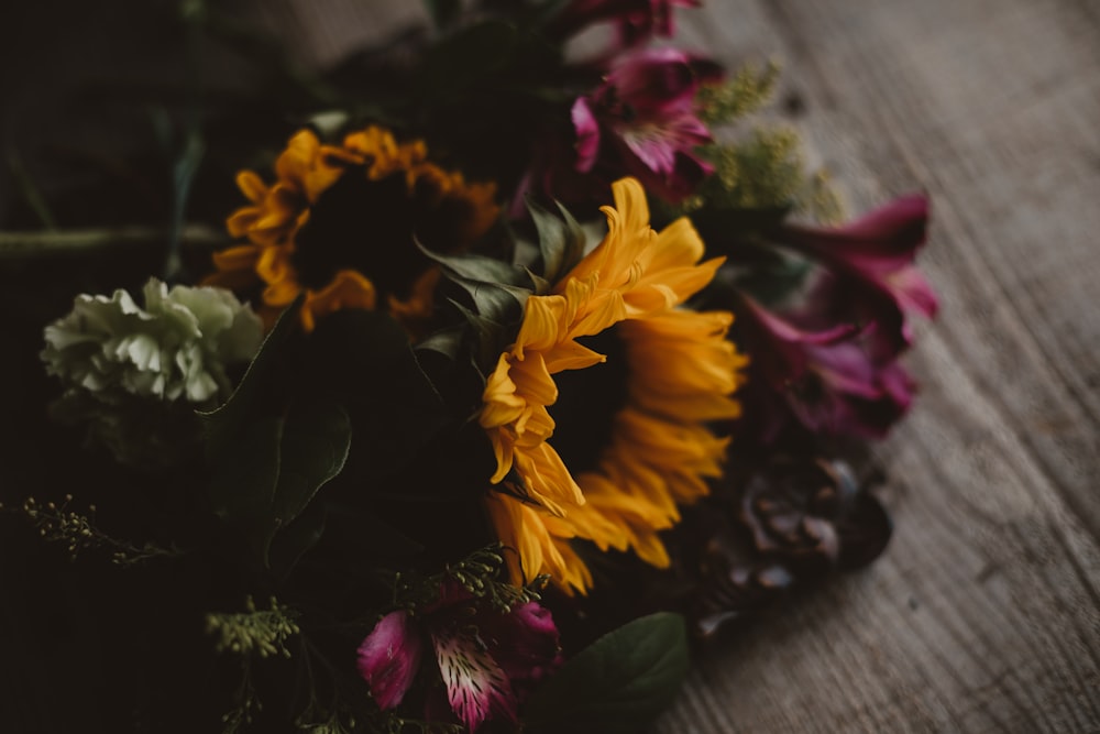 yellow and red flower on gray wooden table