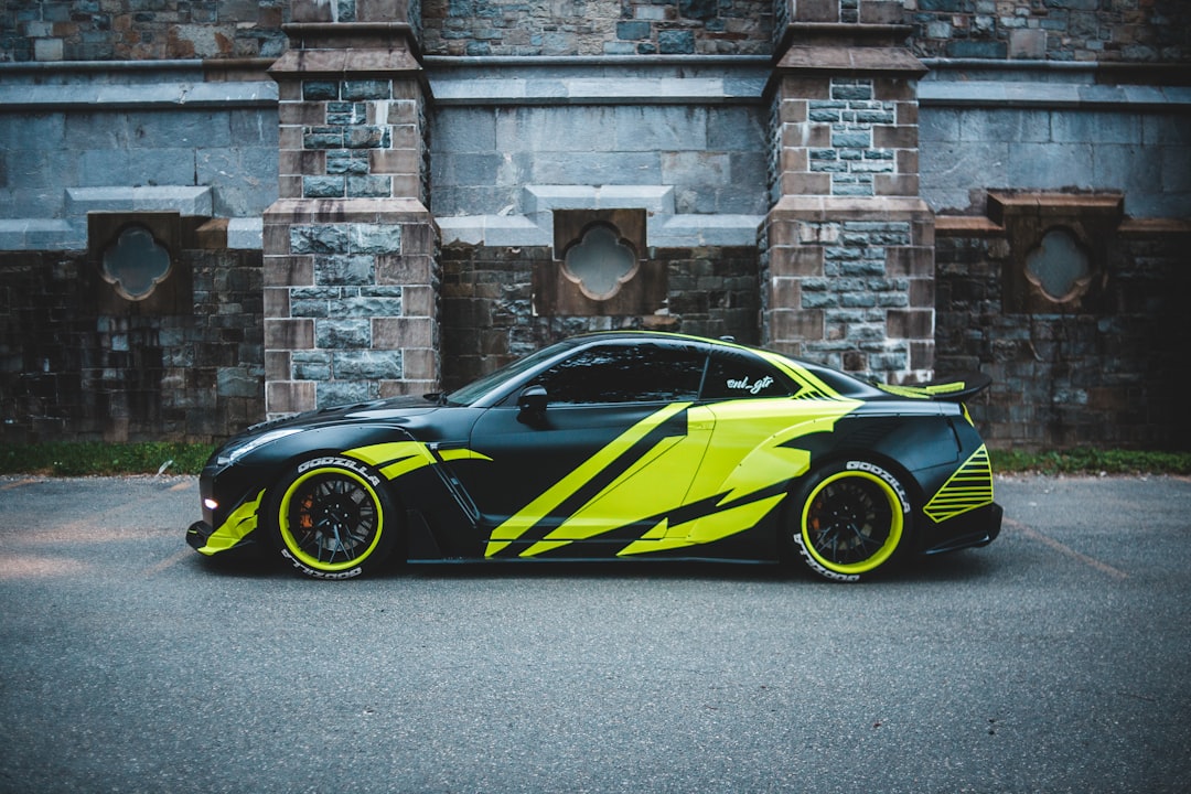 black and yellow ferrari sports car parked beside brown brick wall