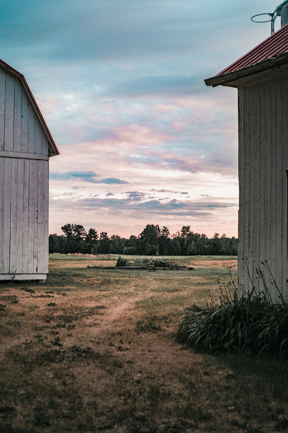 white wooden house on green grass field under cloudy sky during daytime