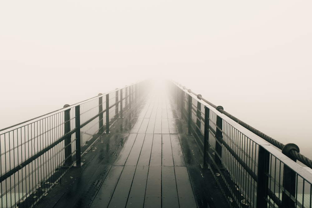 a foggy bridge with a person walking across it