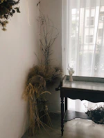 A cozy corner featuring a handcrafted wooden table adorned with dried flower bouquets and vintage decor