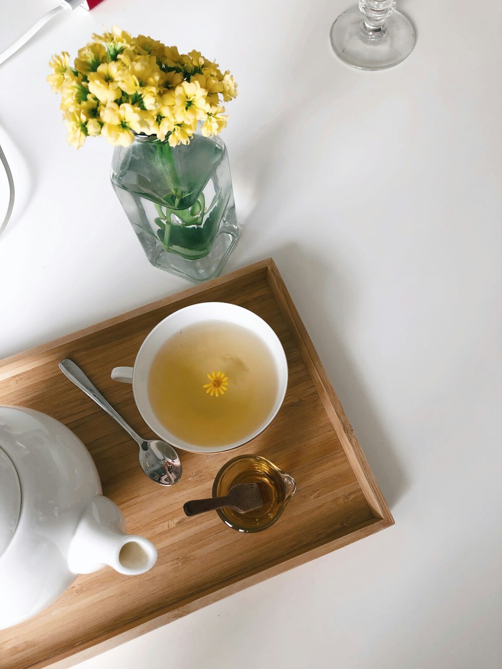 taza de cerámica blanca en platillo de cerámica blanca al lado de la cuchara de acero inoxidable