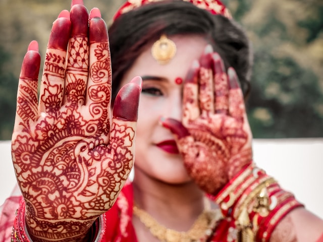 bride showing her mehendi oh her palm.
