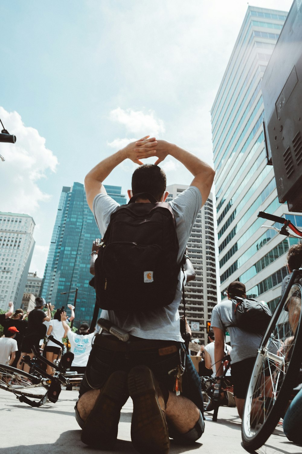 man in black shirt raising his hands