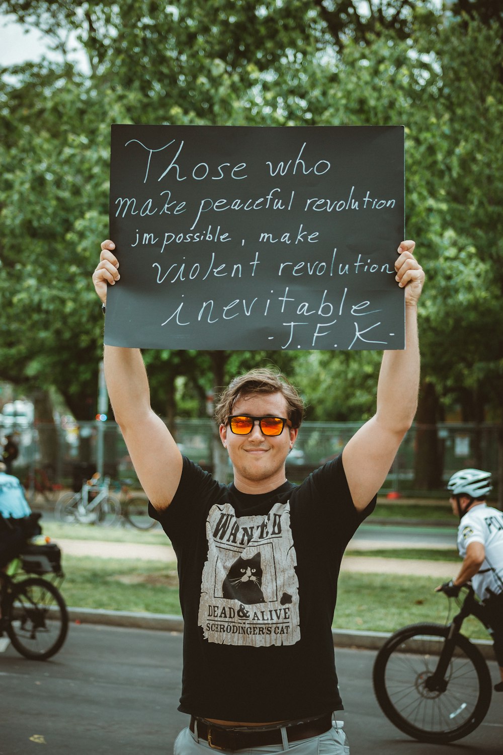 man in black and white crew neck t-shirt holding black and white quote board