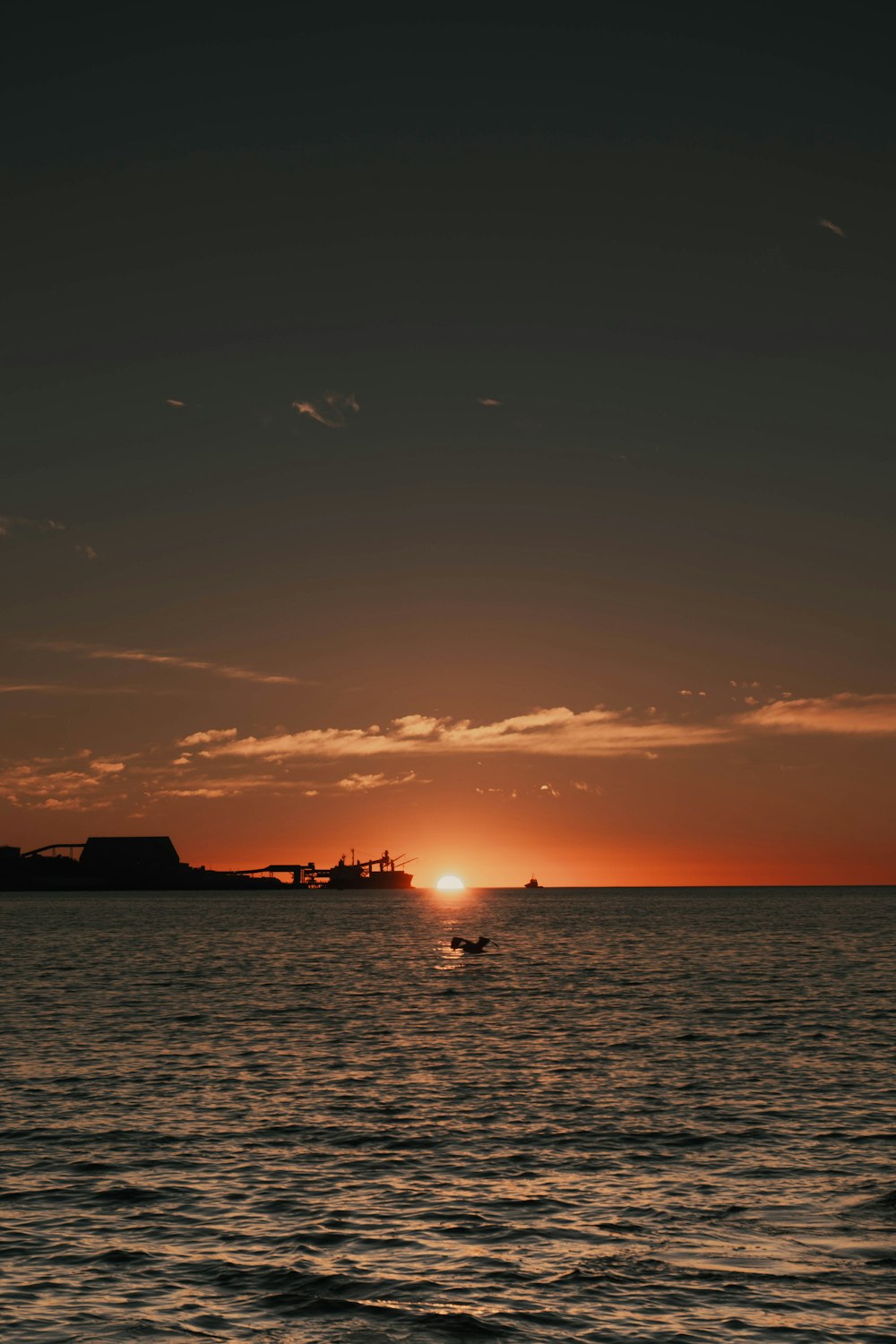 silhouette of boat on sea during sunset