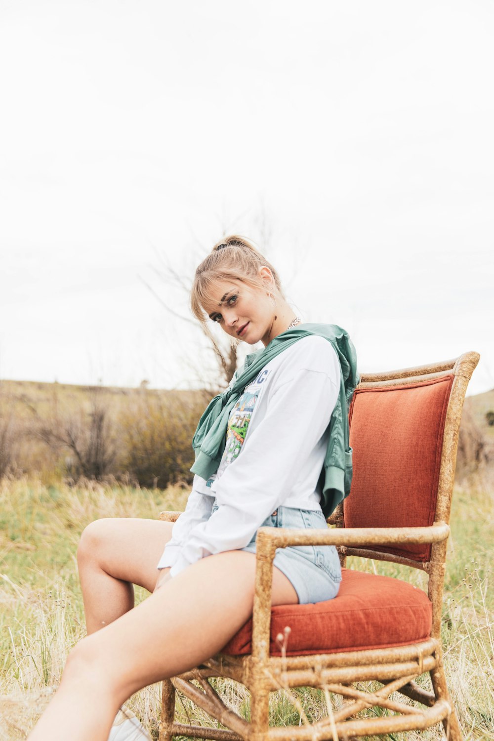 girl in green and white shirt sitting on brown wooden armchair