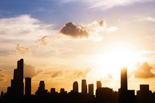 A vibrant Philadelphia skyline at sunset with warm golden light reflecting off the buildings.