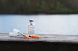 orange and white plastic bottle on brown wooden table