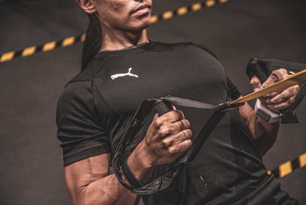 Hombre con camiseta negra Nike de cuello redondo con gafas de sol negras