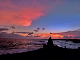 A stunning sunset over the turquoise waters of Cancún with a rainbow flag waving gently.