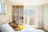 Bright, modern bedroom setup in a small guesthouse with stylish furniture.