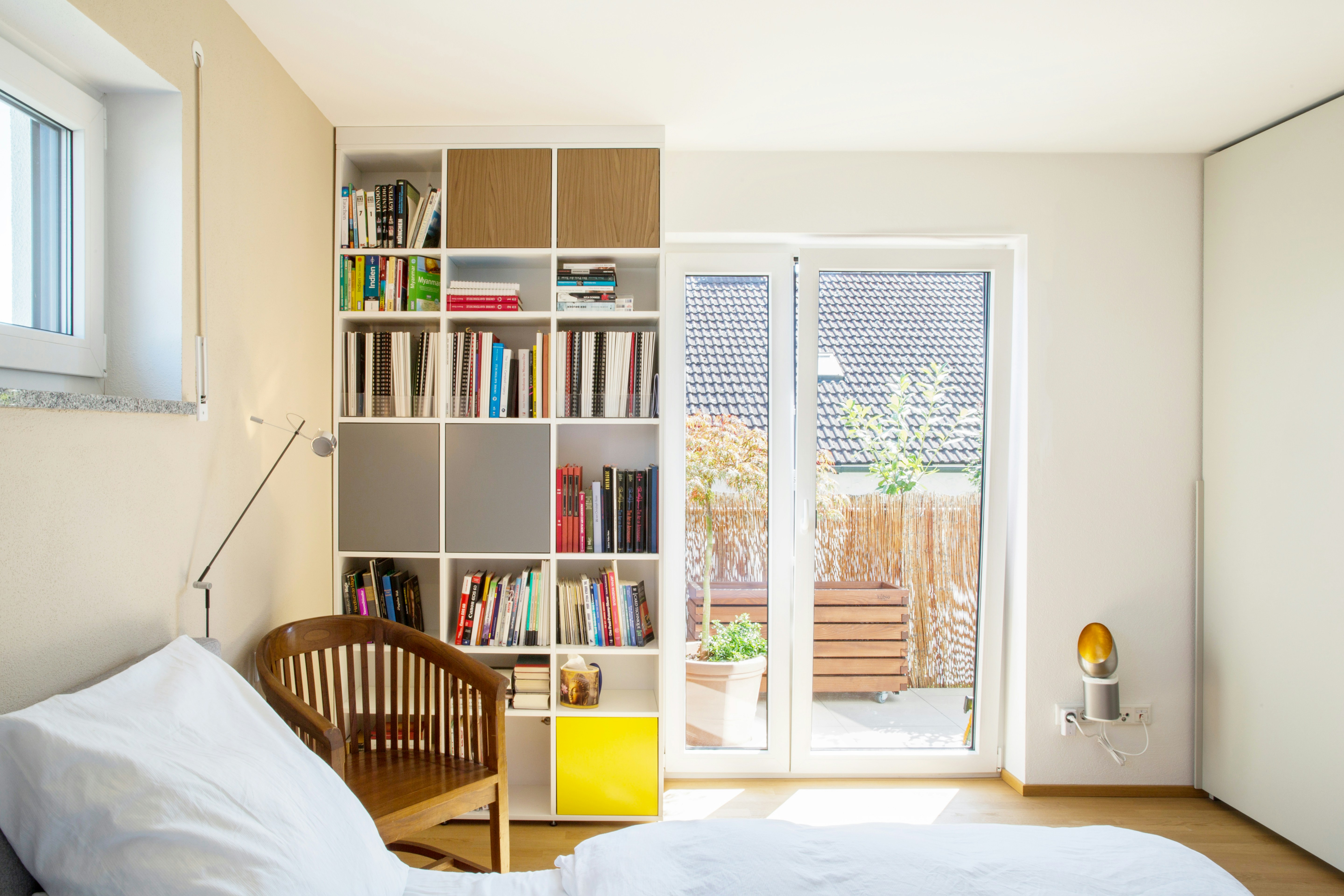 Ceiling-high shelf in a material combination of MDF and solid wood.