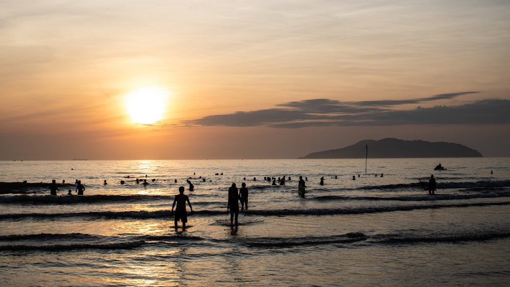 silhouette of people on beach during sunset