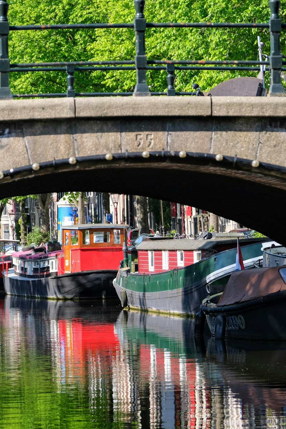 Barco rojo y negro en el río bajo el puente durante el día