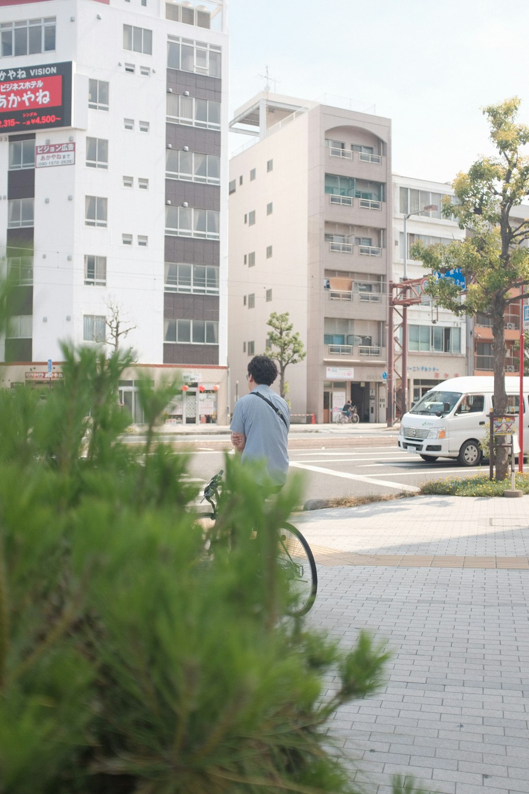 man in white shirt riding bicycle on road during daytime