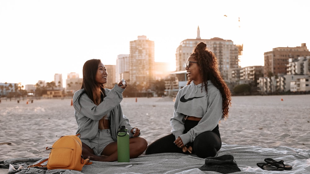 woman in gray hoodie sitting on green plastic container