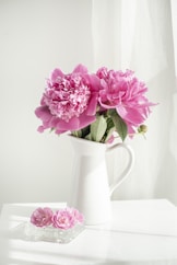 pink and white flowers in white ceramic vase