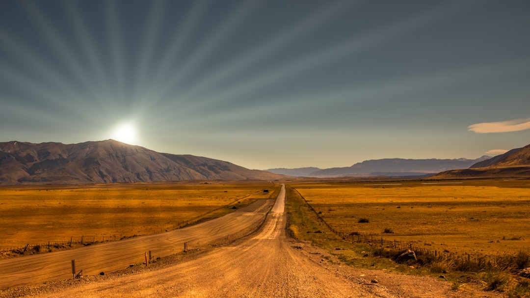 brown field near brown mountain under blue sky during daytime, Sandroad to the horizon<p></figure>