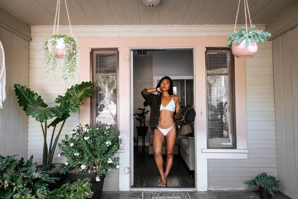 woman in black crop top and black shorts standing near door