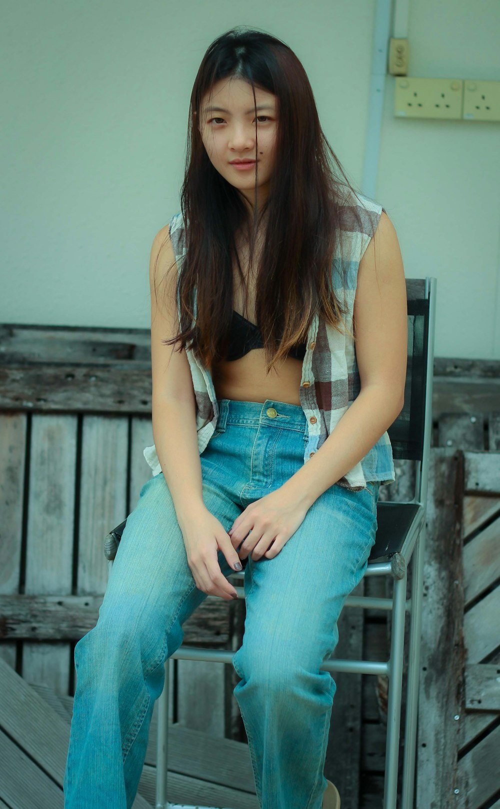 woman in blue denim shorts sitting on brown wooden chair