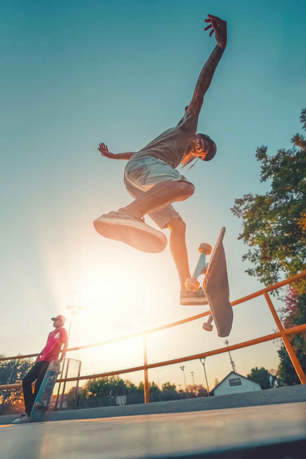 man in blue shirt and brown shorts jumping on air during daytime