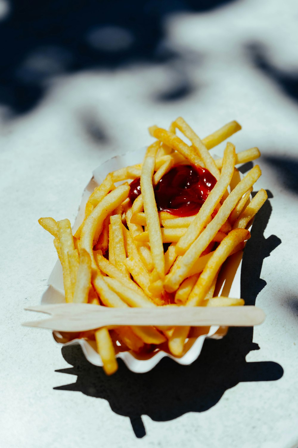 french fries with ketchup on white paper
