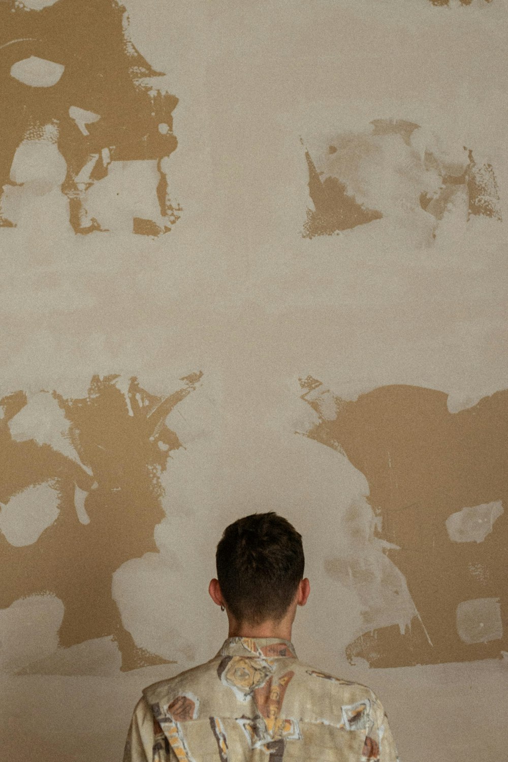 man in black shirt standing near white wall