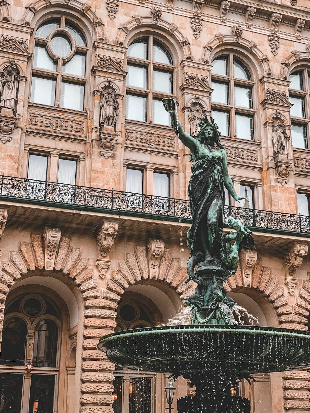 Estatua verde del hombre que sostiene la estatua del libro