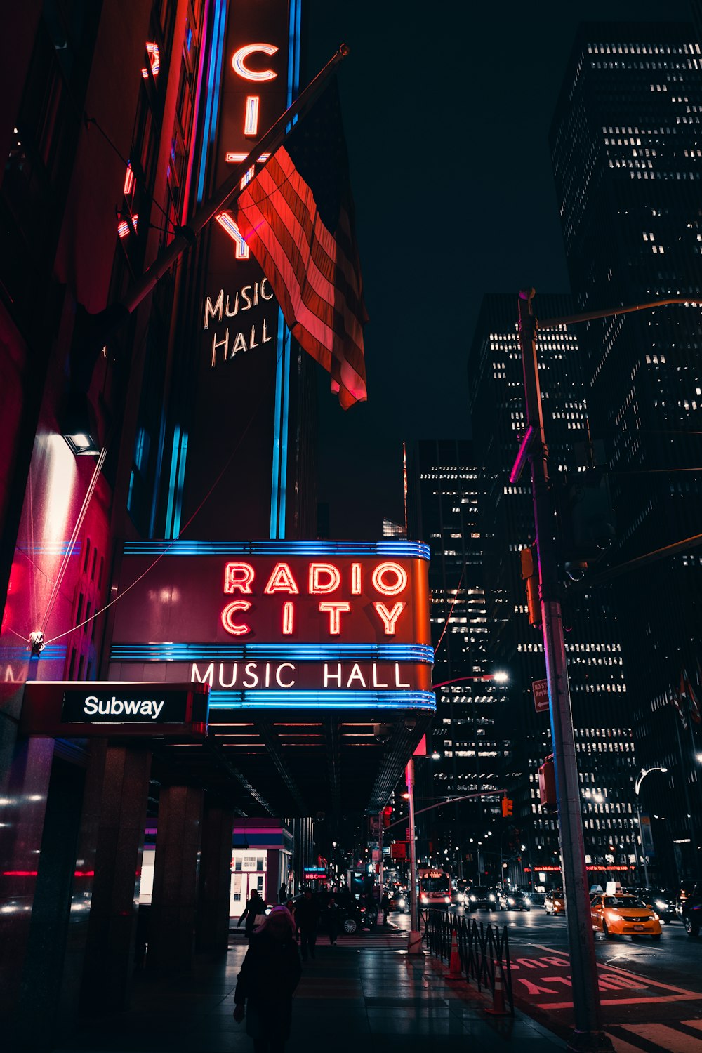 the radio city sign is lit up at night