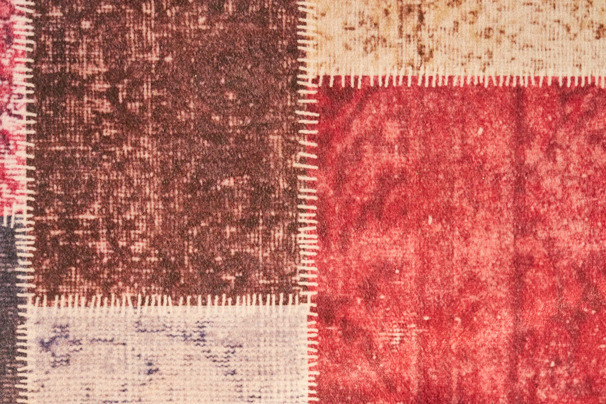 Patchwork fabric squares in various patterns laid out for a quilt design