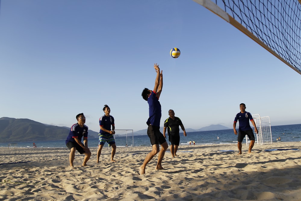 Gente jugando voleibol bajo el cielo azul durante el día