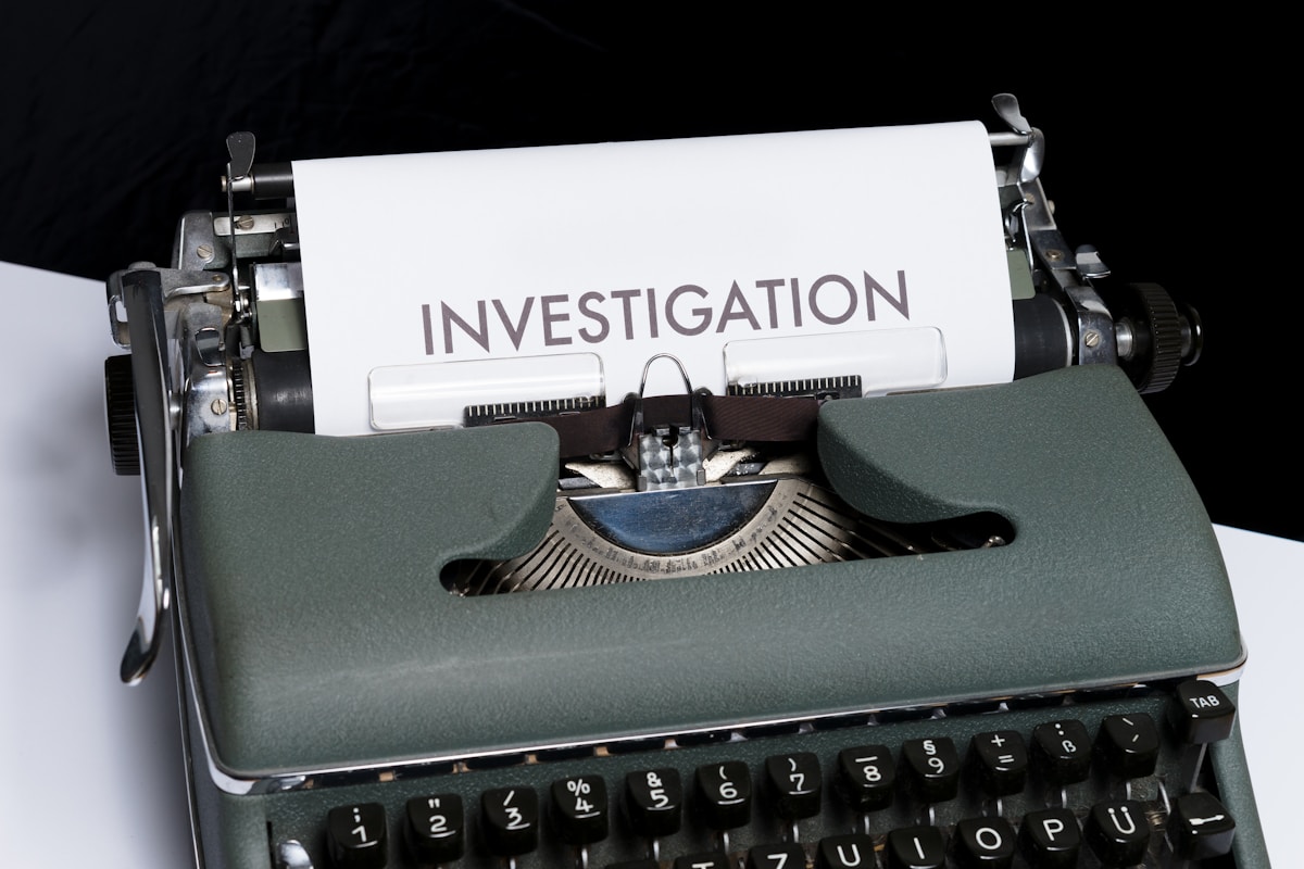 And old fashioned typewriter wtih a piece of paper in it that has the word INVESTIGATION