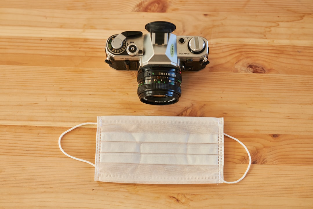 black and silver dslr camera on brown wooden table