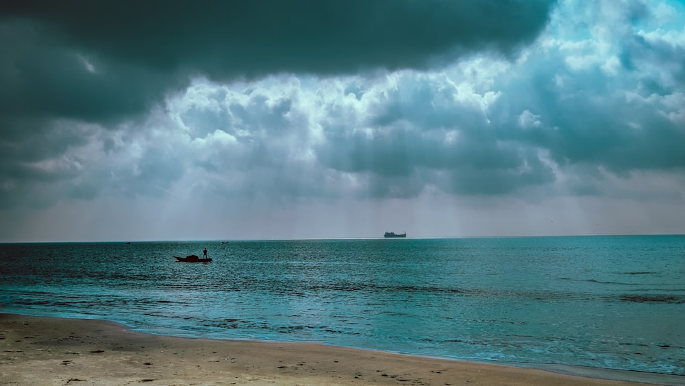 people surfing on sea under white clouds and blue sky during daytime