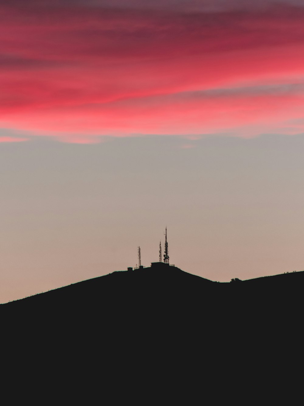 silhouette of person standing on top of mountain during sunset