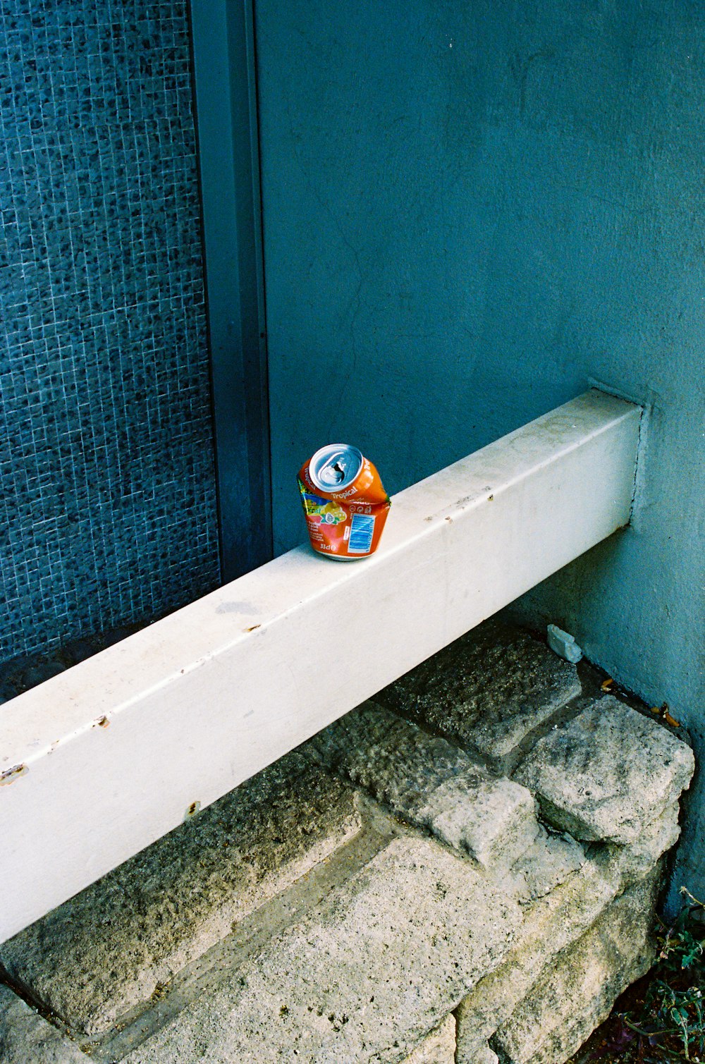 orange and white labeled can on white wooden table