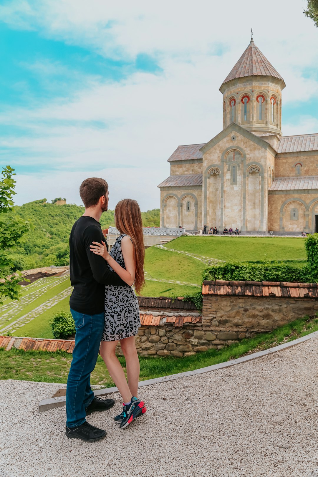 couple standing near brown concrete building during daytime