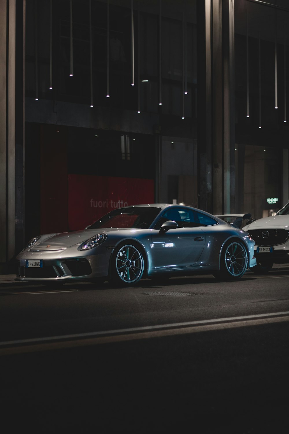 black porsche 911 parked in front of building