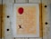 A framed poster with text that outlines the right to freedom of movement and residence within national borders. The poster is adorned with a large red balloon and an illustration of a figure holding onto the balloon string. The frame and wall have a rustic, textured appearance.