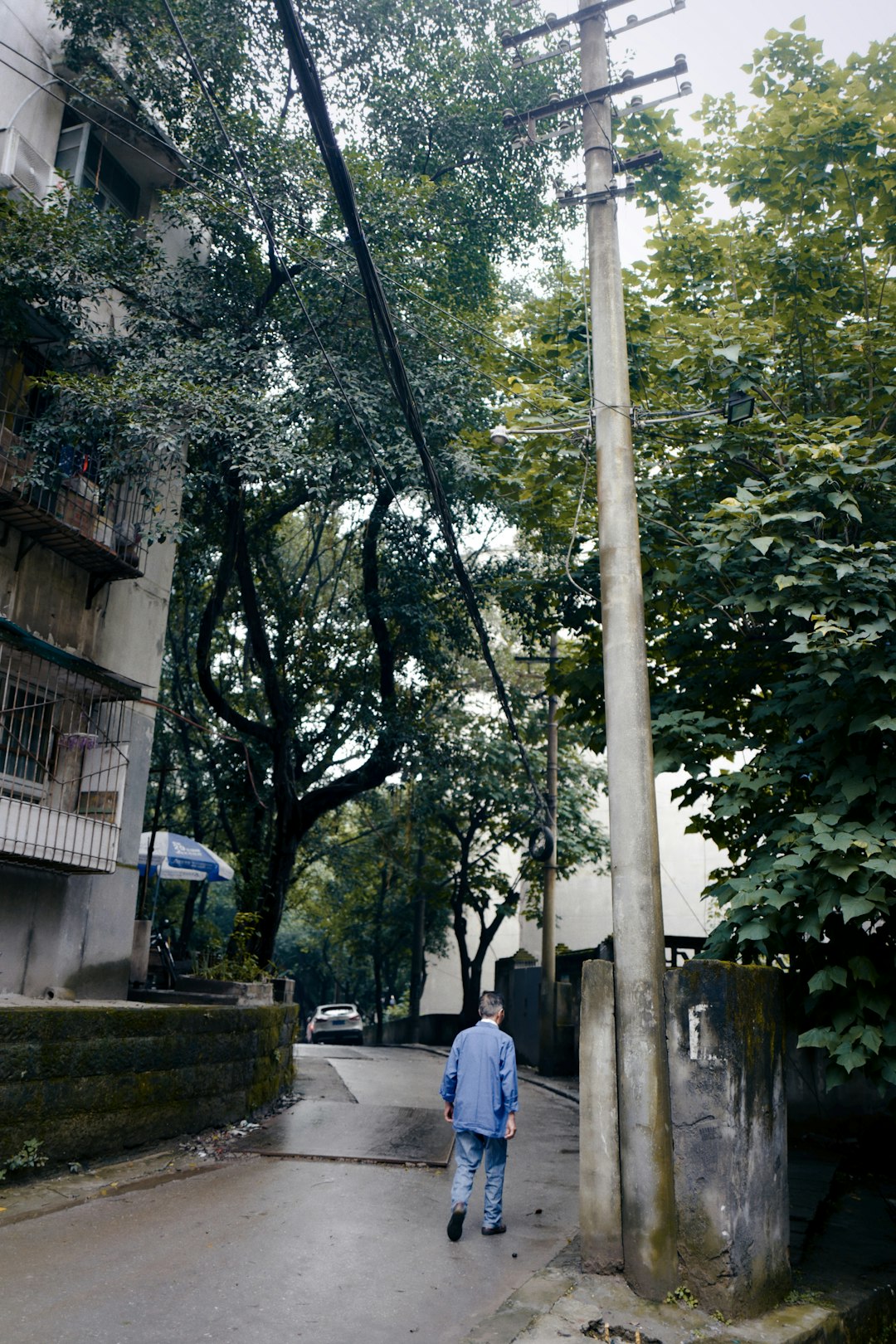 woman in blue dress walking on sidewalk during daytime