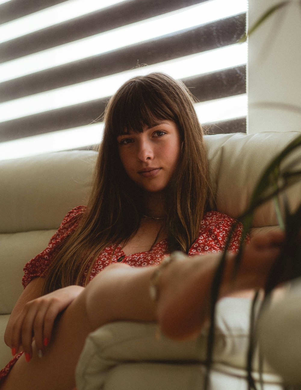 woman in red and white floral dress sitting on white couch