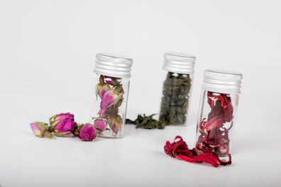 Close-up of natural herbal teas in glass jars with dried flowers.