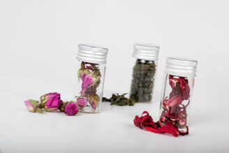 Close-up of natural herbal teas in glass jars with dried flowers.