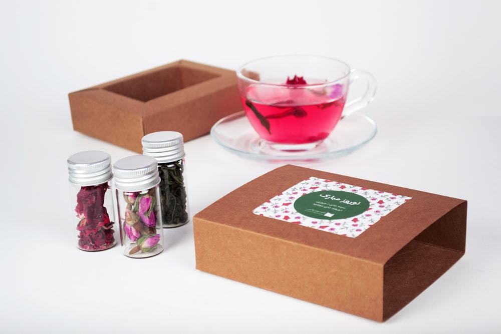 red and brown carton box beside clear glass cup