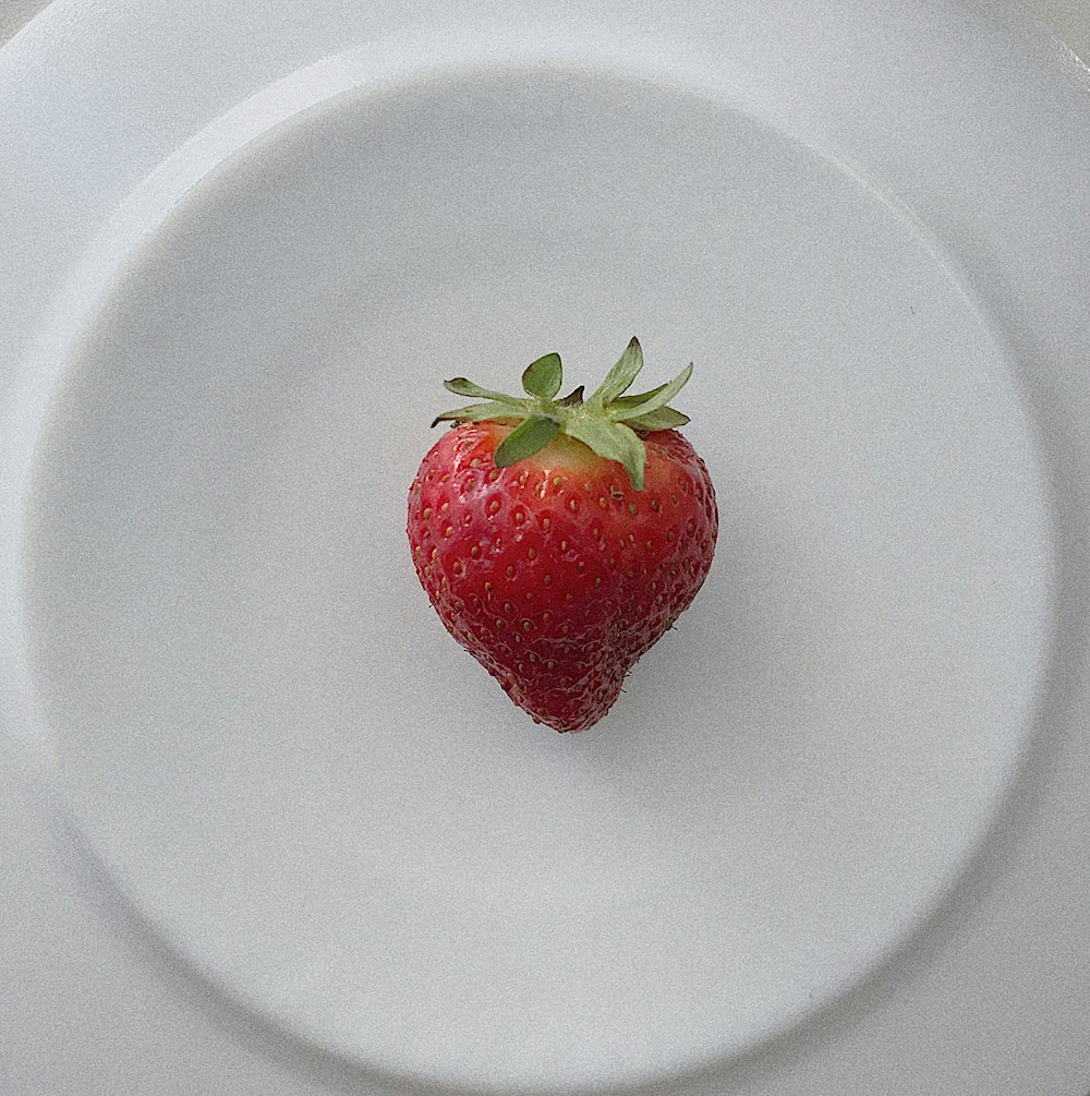 strawberry on white ceramic plate