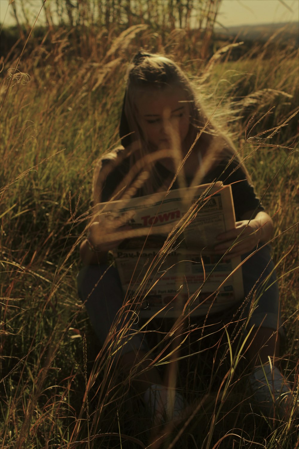 woman in brown and black long sleeve shirt sitting on green grass field