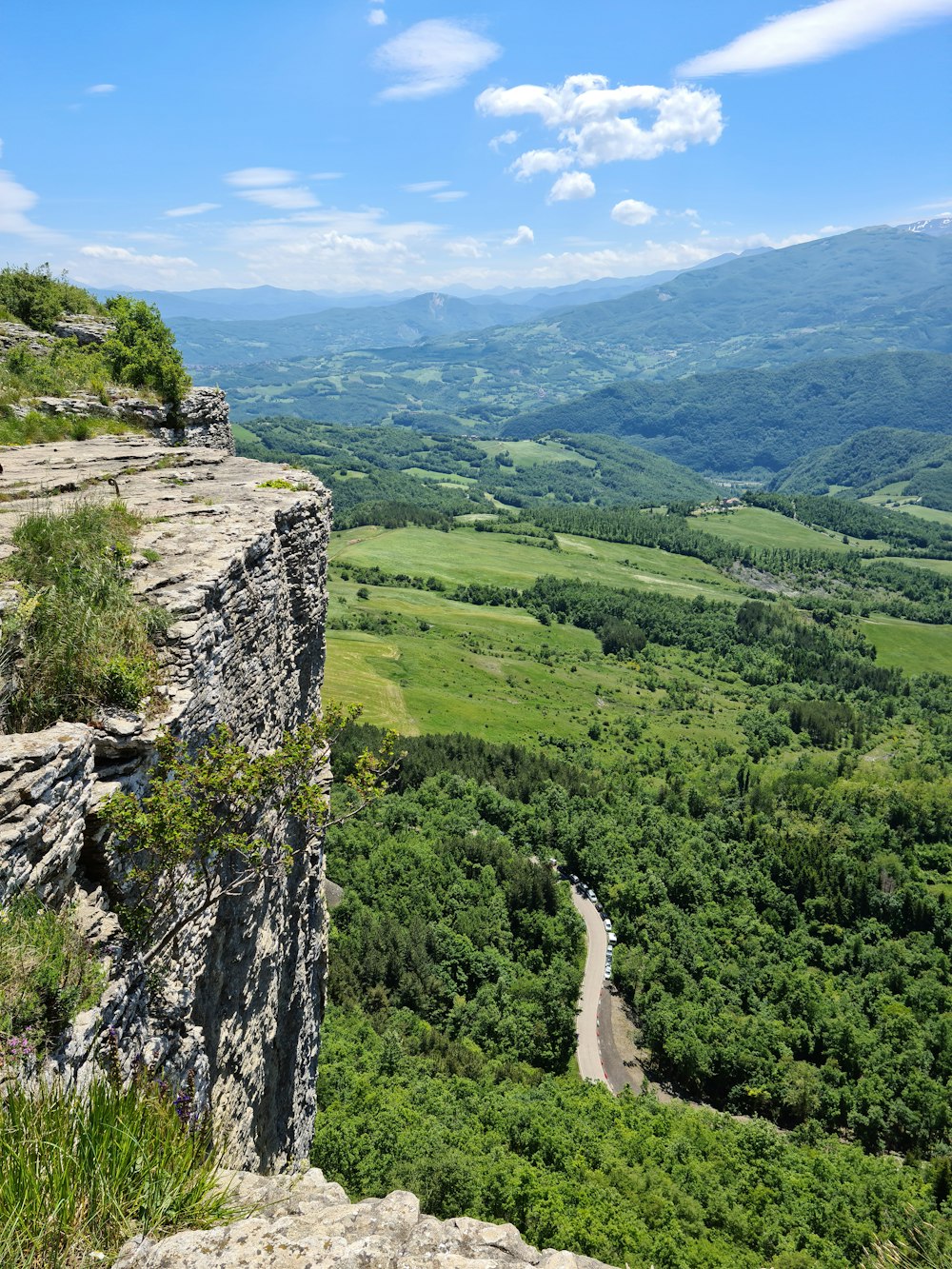 Persona con camisa blanca de pie en la montaña rocosa durante el día