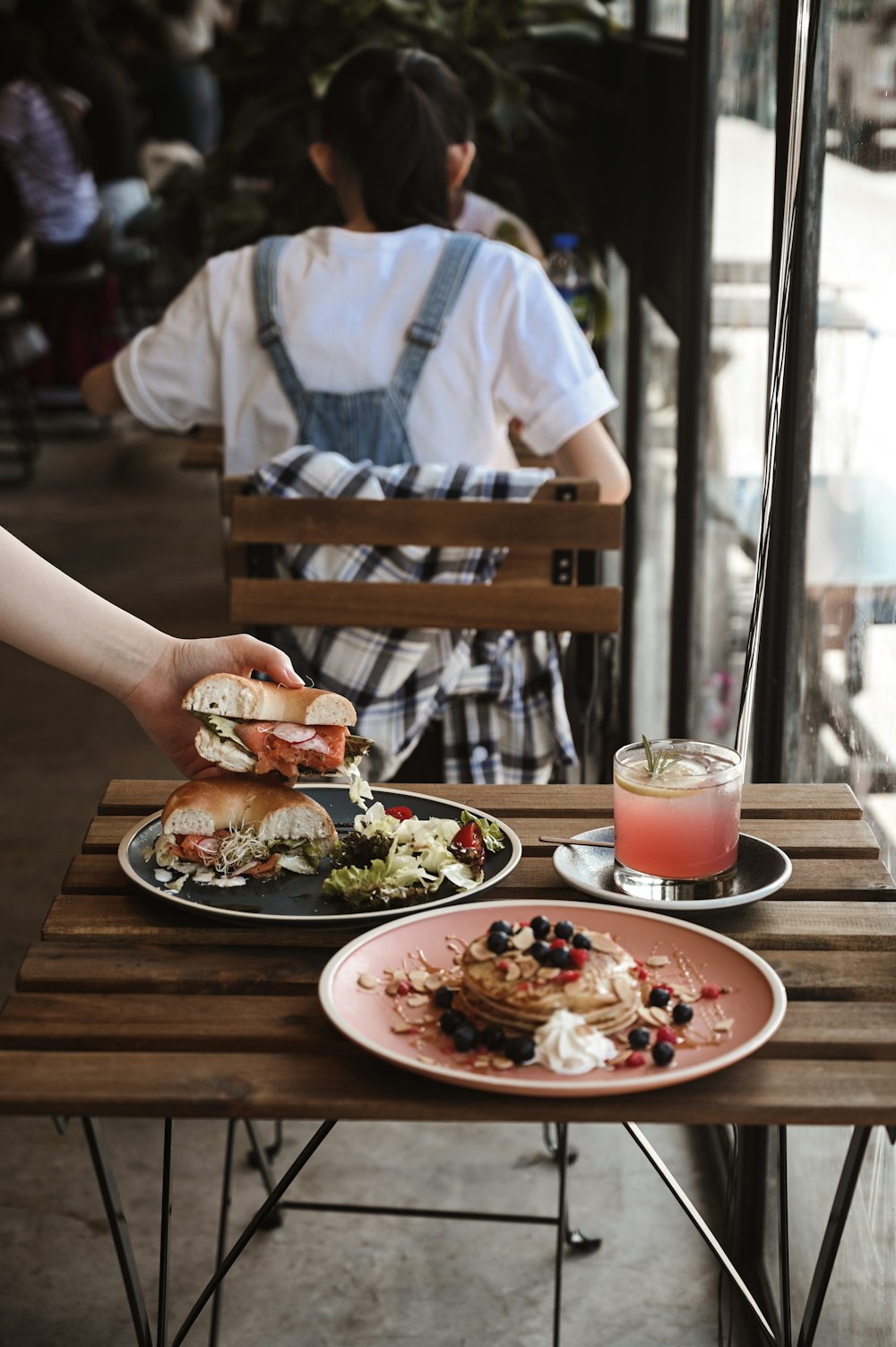 person in white shirt holding white ceramic plate with food